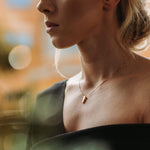 Annette wears a gold pendant by Ekenberg